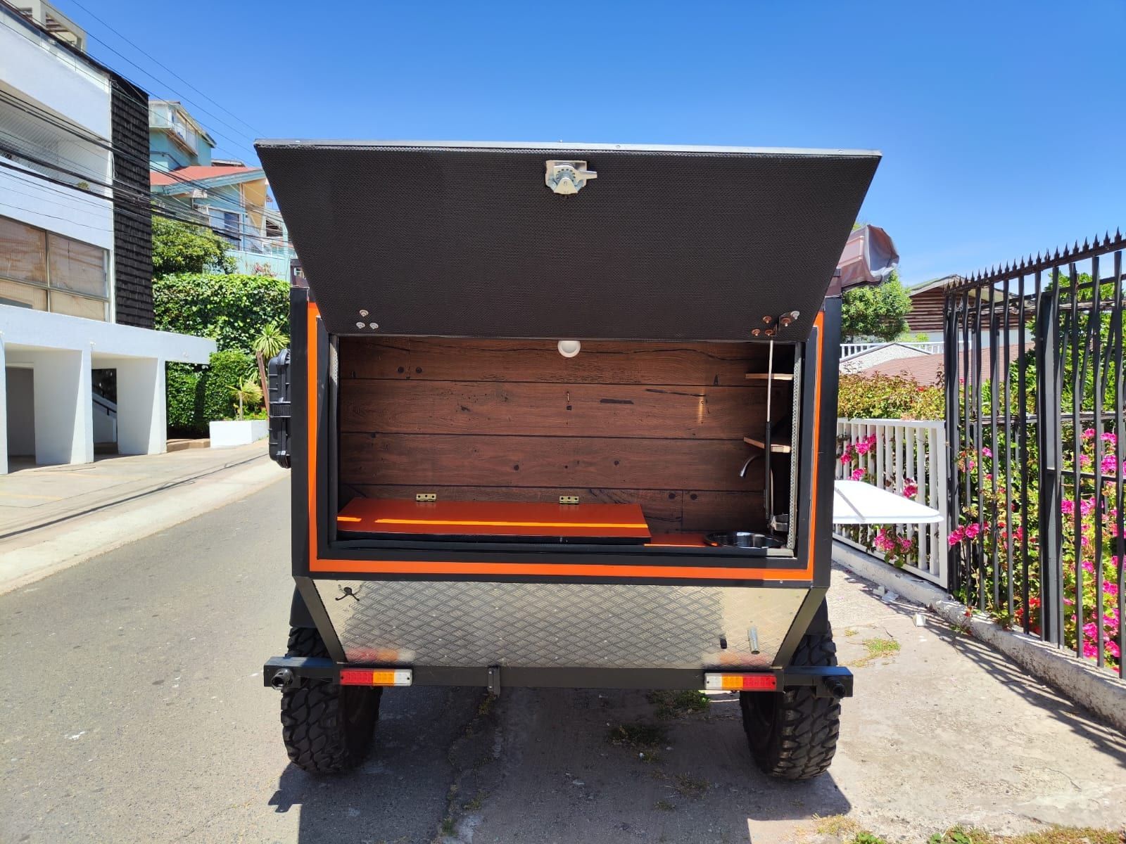 Interior del mini camper con piso de madera y catre para descanso