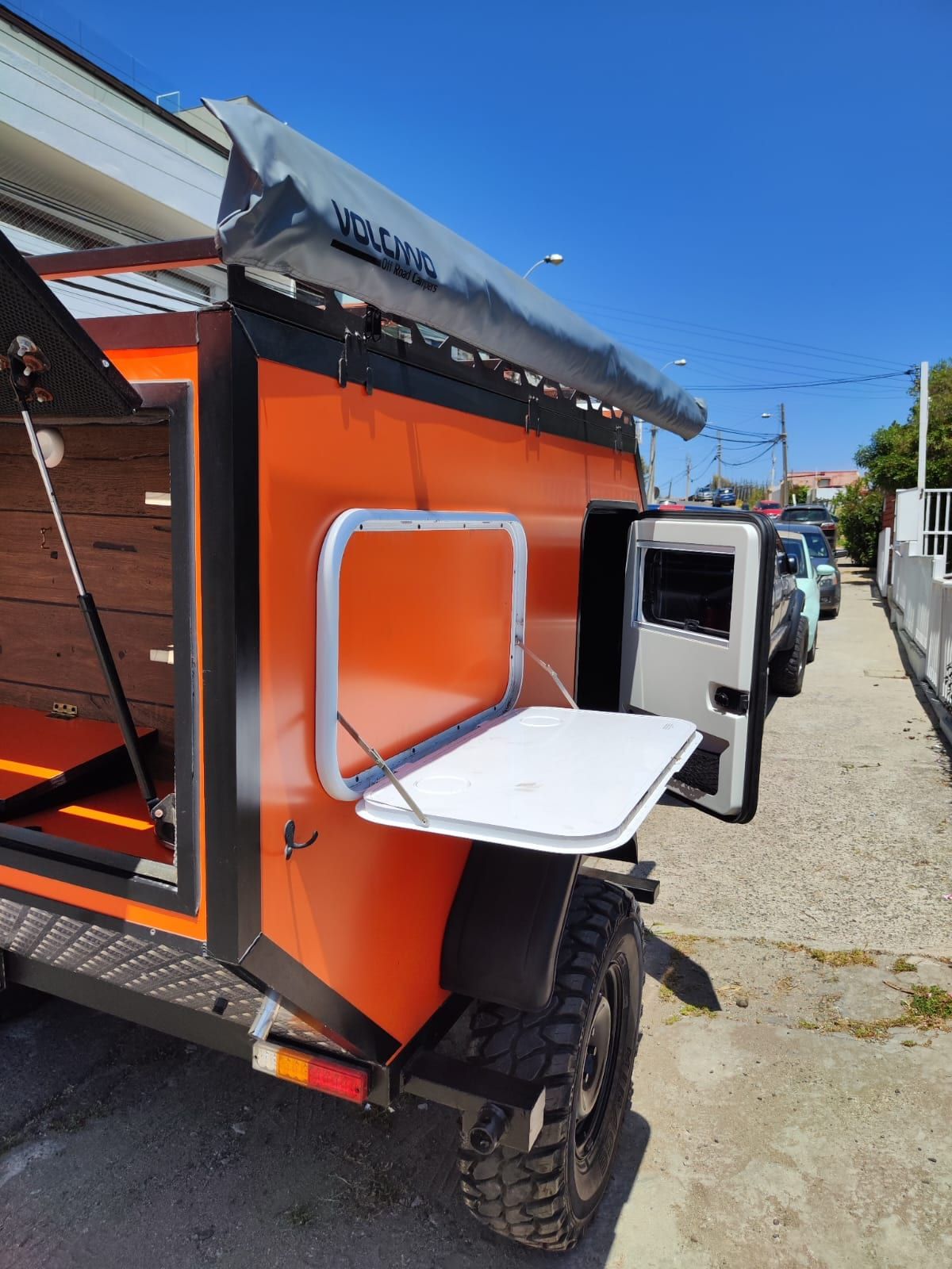 Detalle del lado del mini camper con mesa lateral abierta y bomba de agua